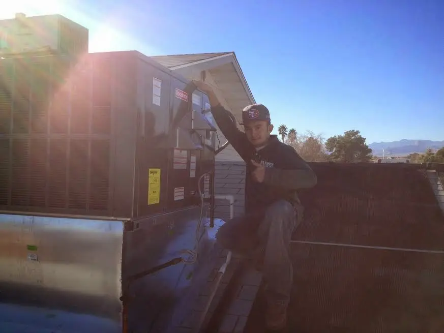 HVAC technician performing Boiler Repair on a rooftop unit in Dover